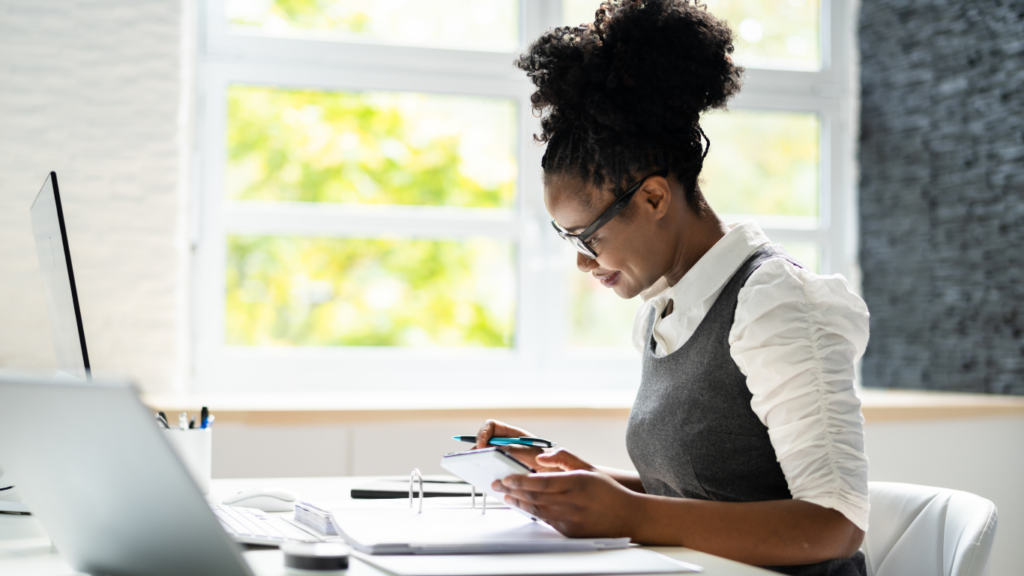 Une femme assise devant l'ordinateur et gère son Business en ligne